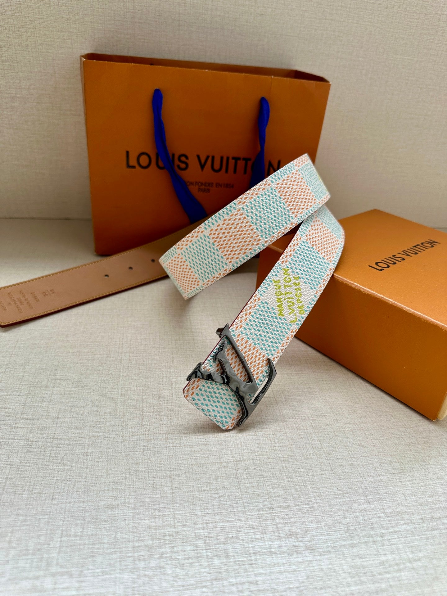 Louis Vuitton canvas belt with light blue and white pattern and silver buckle.