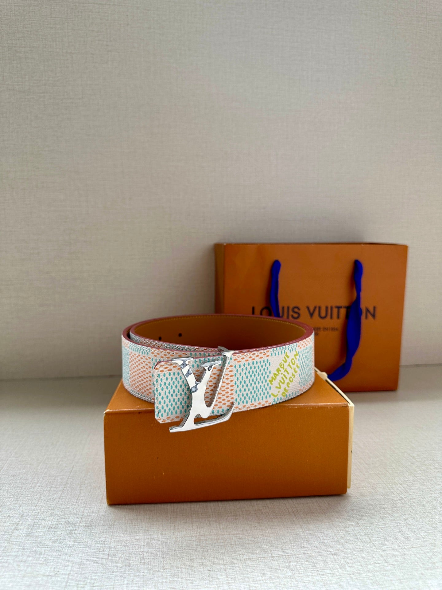 Louis Vuitton canvas belt with light blue and white patterned strap and silver buckle.