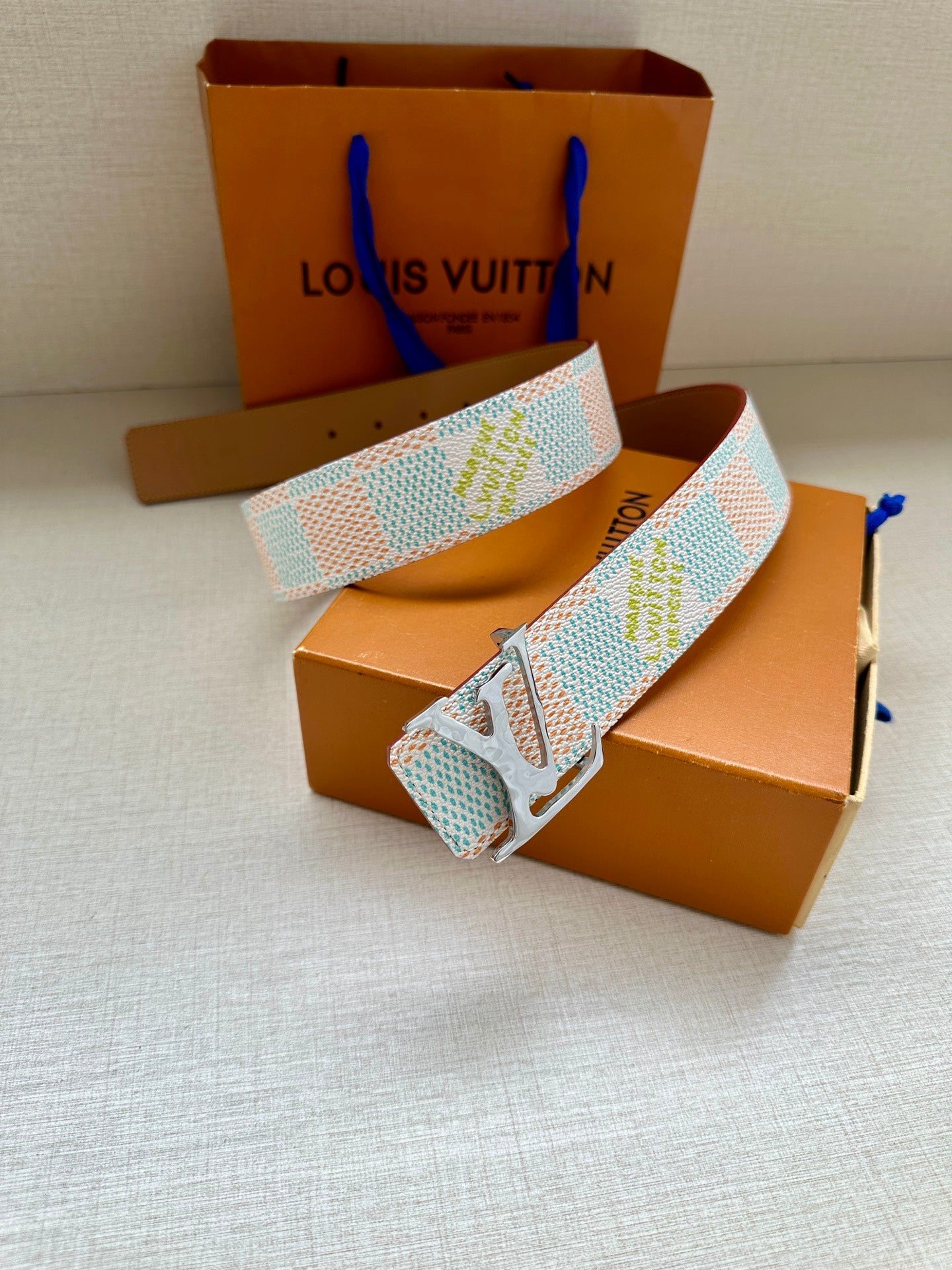 Louis Vuitton belt with light blue and white canvas pattern and silver buckle.