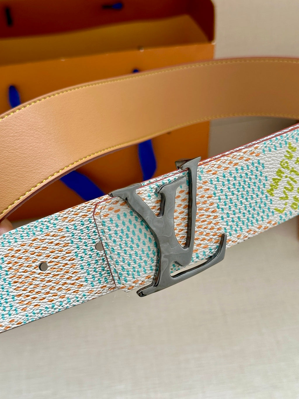 Louis Vuitton belt buckle and light blue/white canvas strap with tan leather edging.