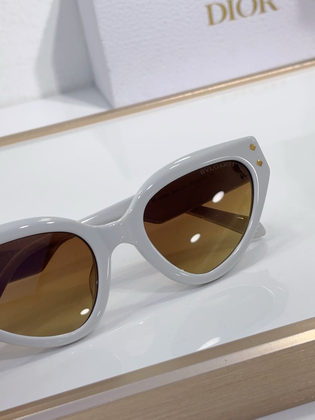 Bvlgari cat-eye sunglasses close-up with white frames and brown tinted lenses
