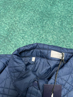 Navy quilted jacket with stand collar and snap closure detail