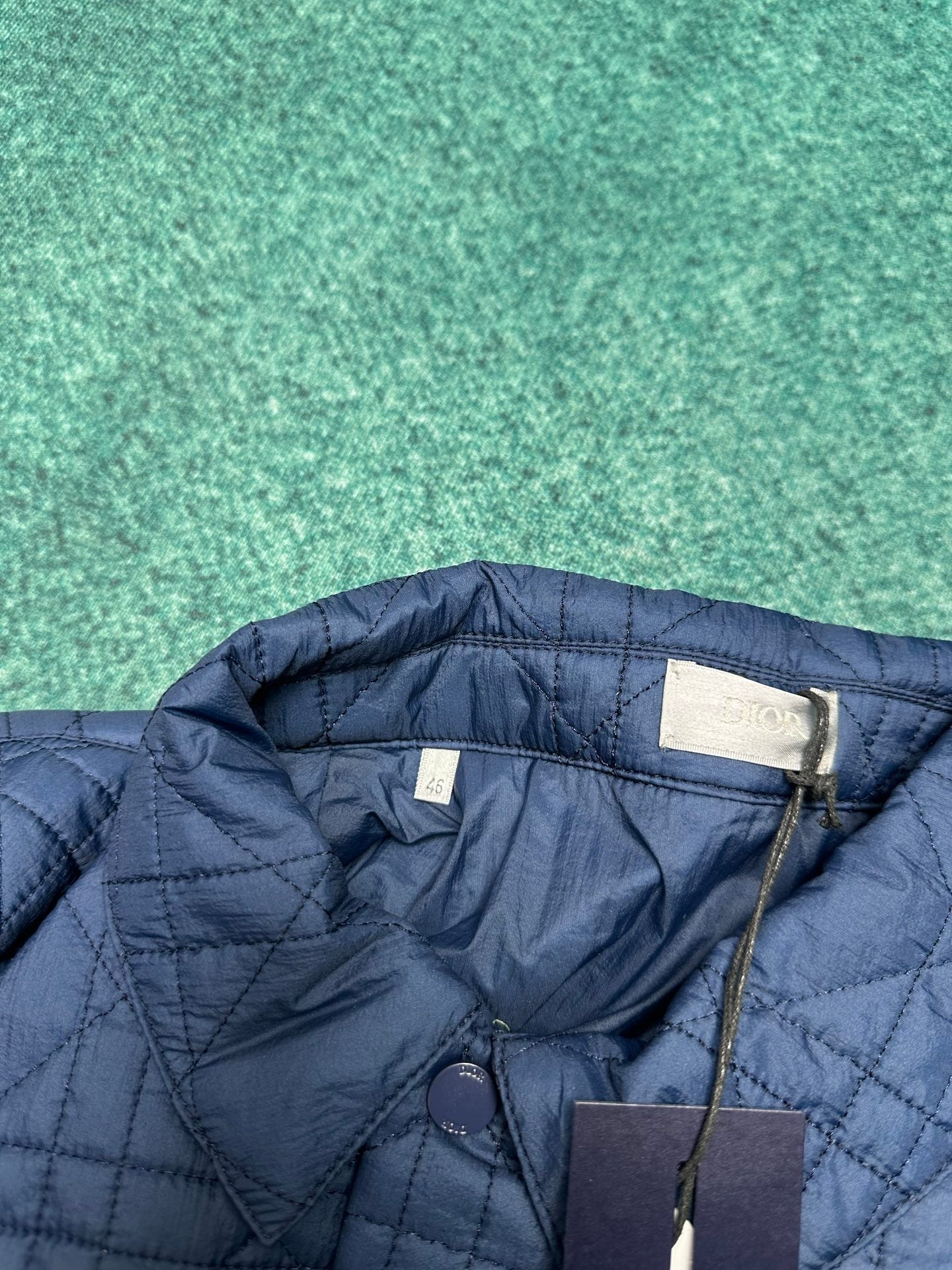 Navy quilted jacket with stand collar and snap closure detail