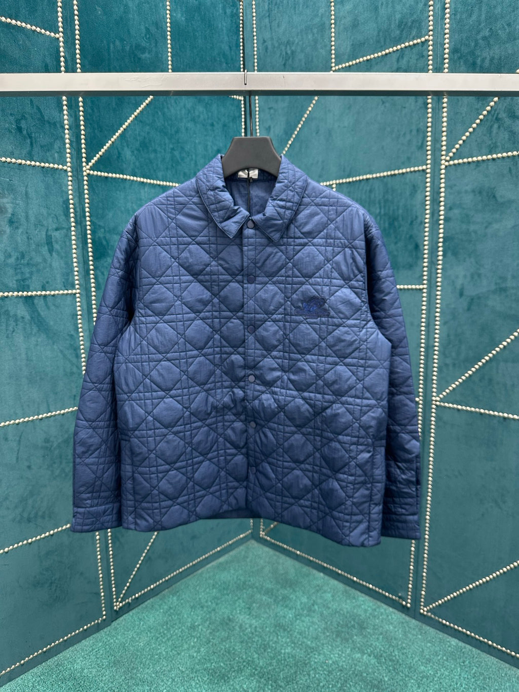 Navy quilted long-sleeve jacket with stand collar and front button placket