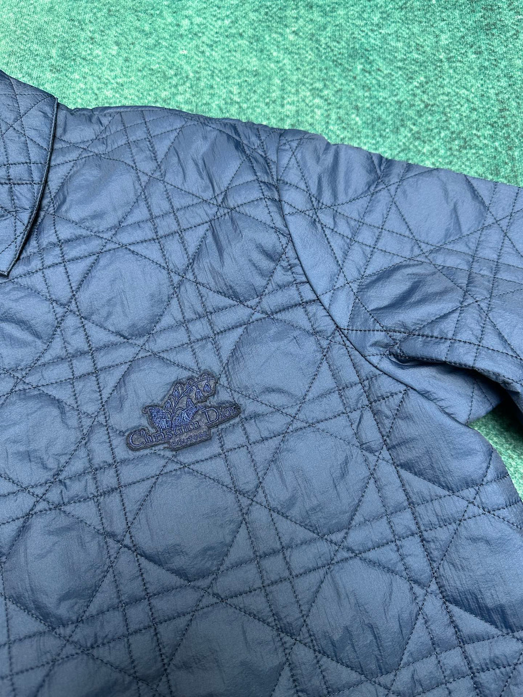 Navy quilted jacket front with small crest logo on chest