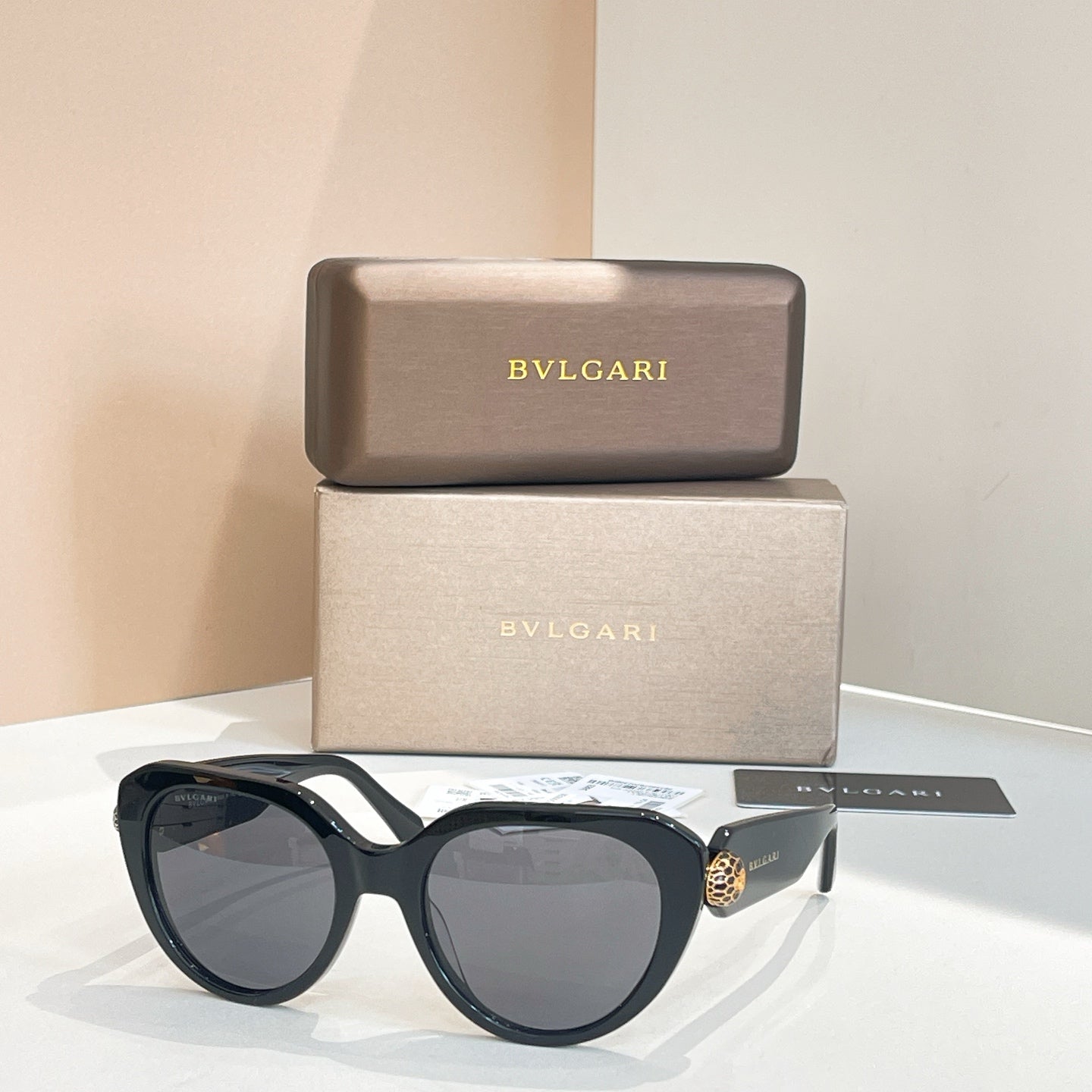 Bvlgari round sunglasses with dark gray lenses and black frames, gold side detail