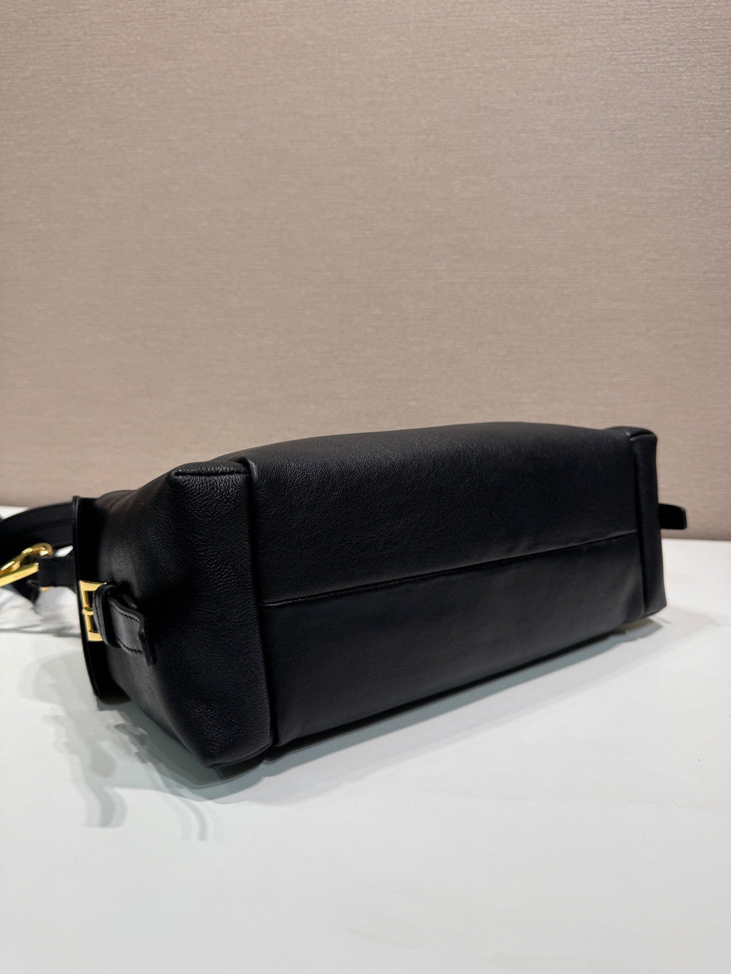 Prada black leather clutch-style pouch with gold-tone hardware and top handle.