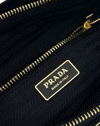 Prada inner logo tag on black fabric lining with gold zipper track.