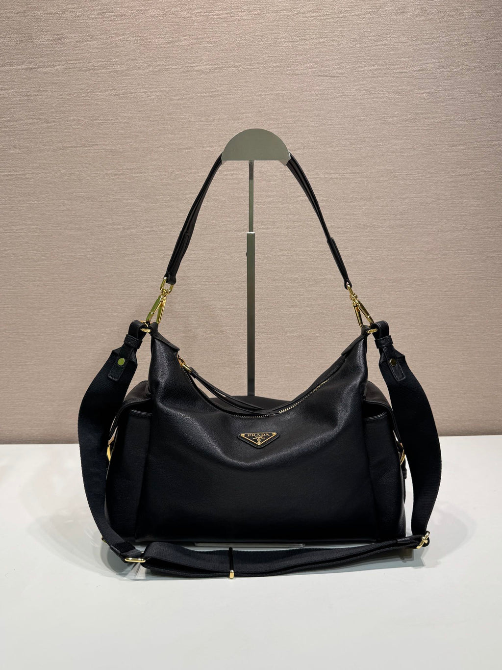 Prada hobo shoulder bag in black leather, gold-tone hardware and logo plaque.