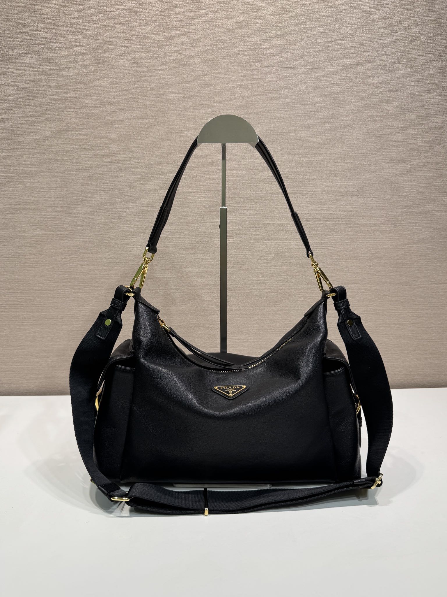 Prada hobo shoulder bag in black leather, gold-tone hardware and logo plaque.