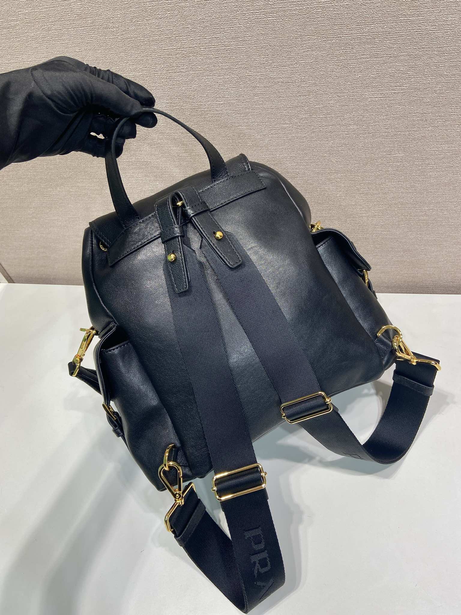 Prada dark blue mini backpack with slouchy top, buckled straps, and gold hardware