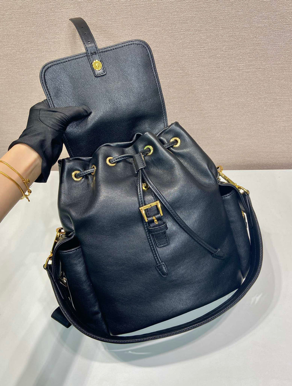 Prada dark blue mini backpack with top handle, front cords, and gold hardware
