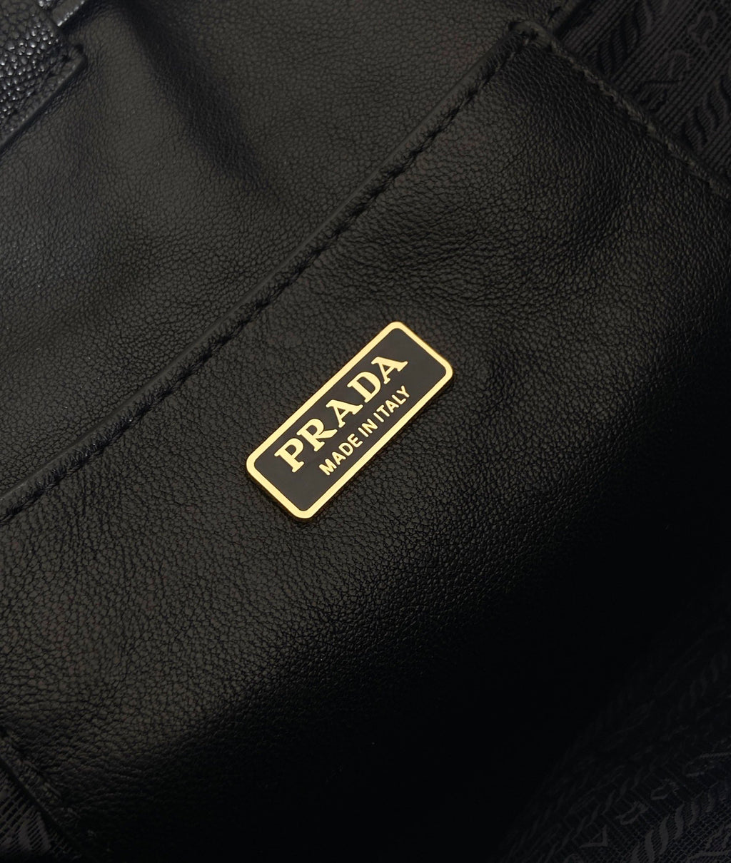 Prada logo patch on dark leather mini bag front panel