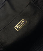 Prada logo patch on dark leather mini bag front panel