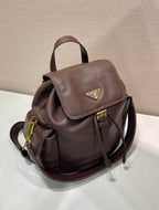 Brown leather mini backpack with flap front, gold-tone hardware, and side zipper pocket