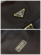 Prada logo patch close-up on dark leather mini backpack with gold trim