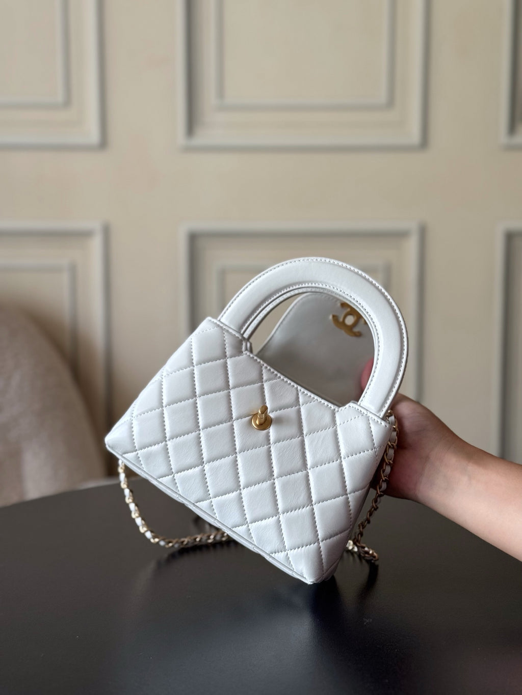 Chanel quilted mini handbag in white with gold CC emblem, angled view