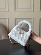 Chanel quilted mini handbag in white with gold CC emblem, angled view