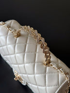 Chanel white quilted flap bag close-up with gold chain detail
