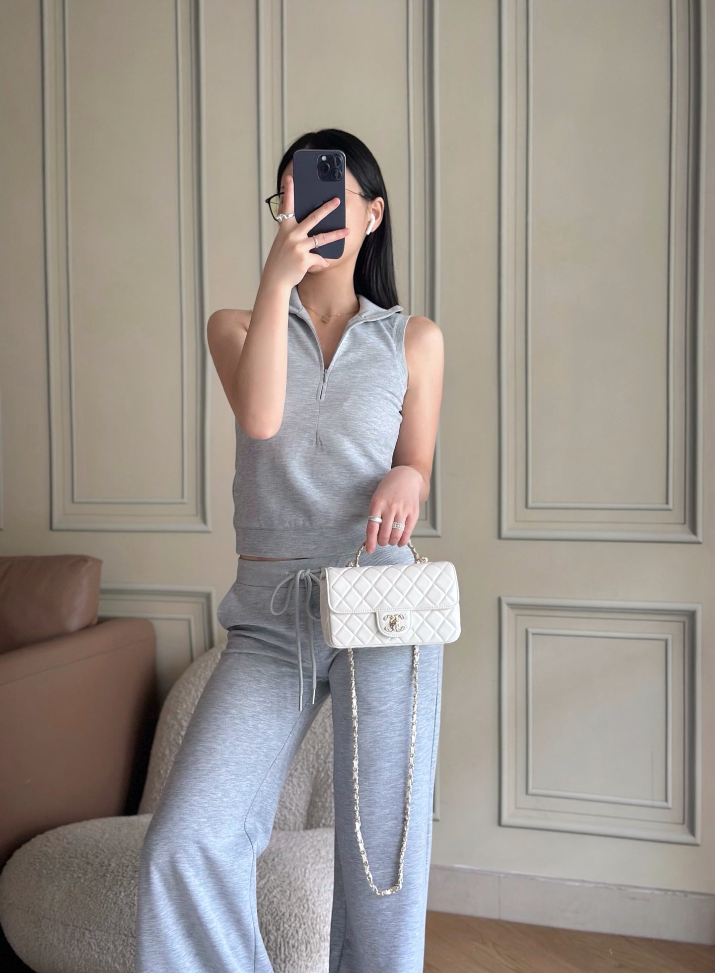 Chanel white quilted flap bag worn crossbody with chain strap