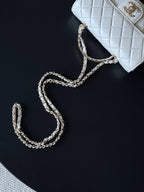 Chanel white quilted flap bag with chain strap on black surface