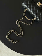 Chanel quilted bag top and chain detail, black with gold-tone logo.