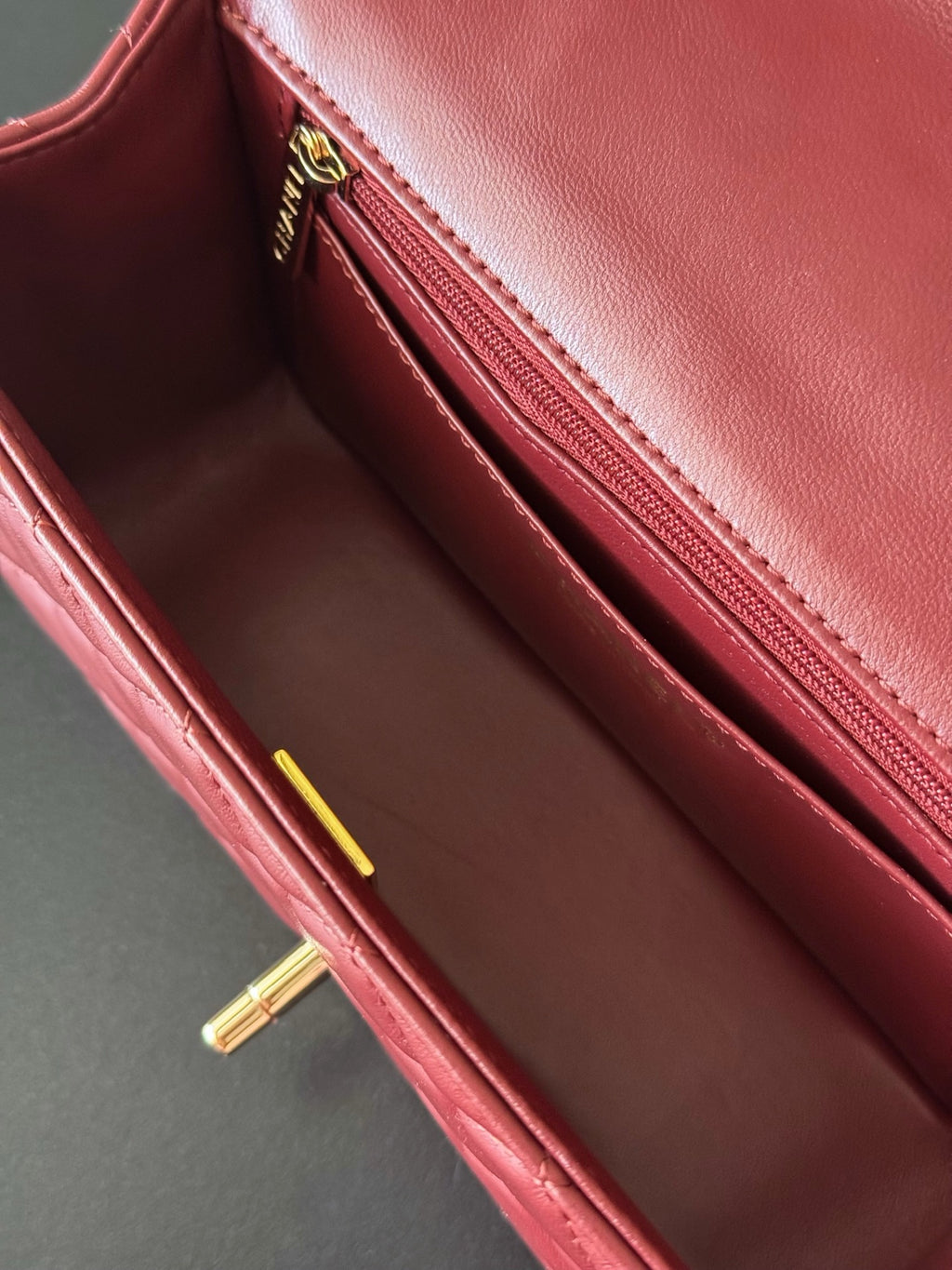 Burgundy leather Chanel handbag interior with zip pocket and stitched lining