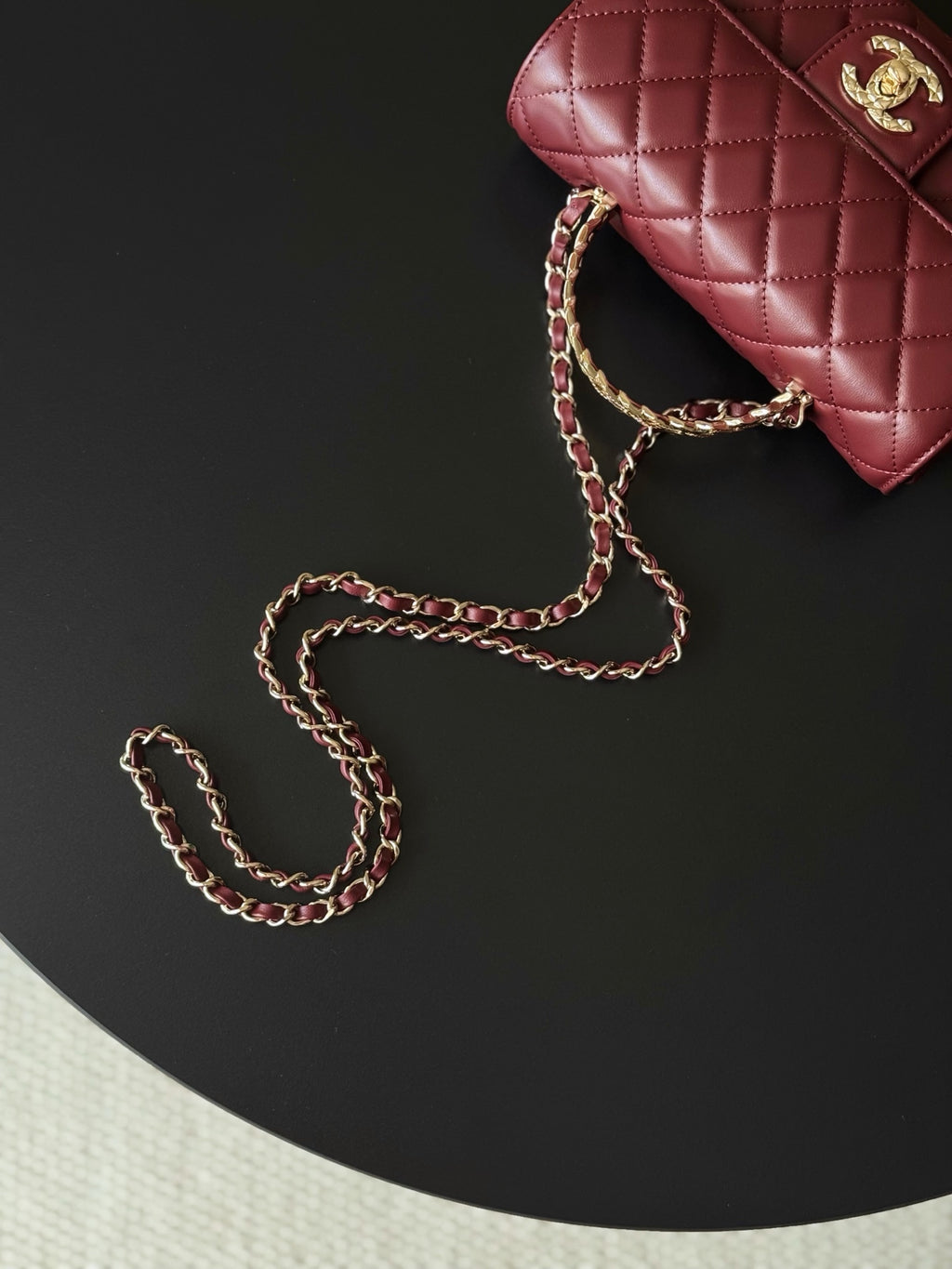 Burgundy quilted leather Chanel handbag with gold chain strap