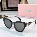 MiuMiu cat-eye sunglasses with black frames and gold-tone temples, tinted dark lenses