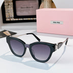 MiuMiu cat-eye sunglasses with dark navy frames and gold-tone temples, tinted purple lenses