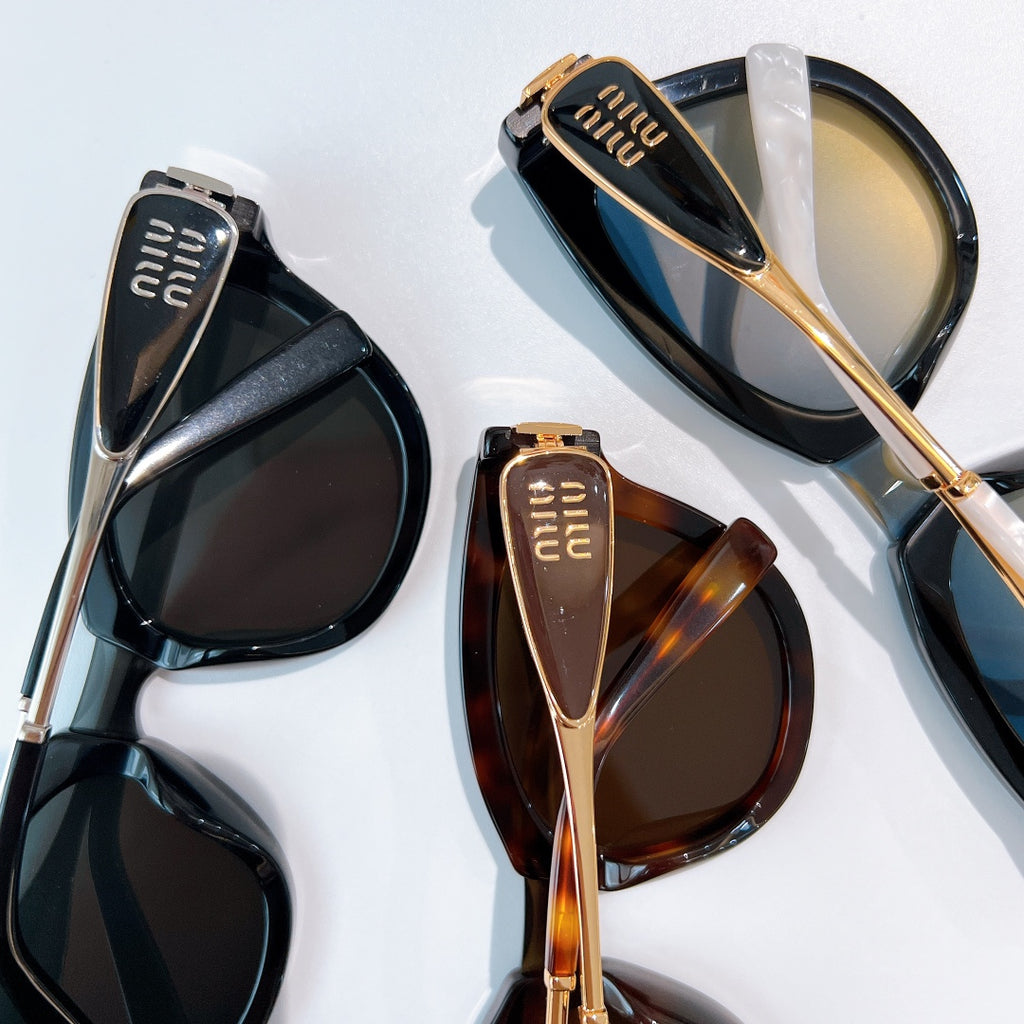 MiuMiu sunglasses pair with black and tortoiseshell frames, gold-tone details, tinted lenses