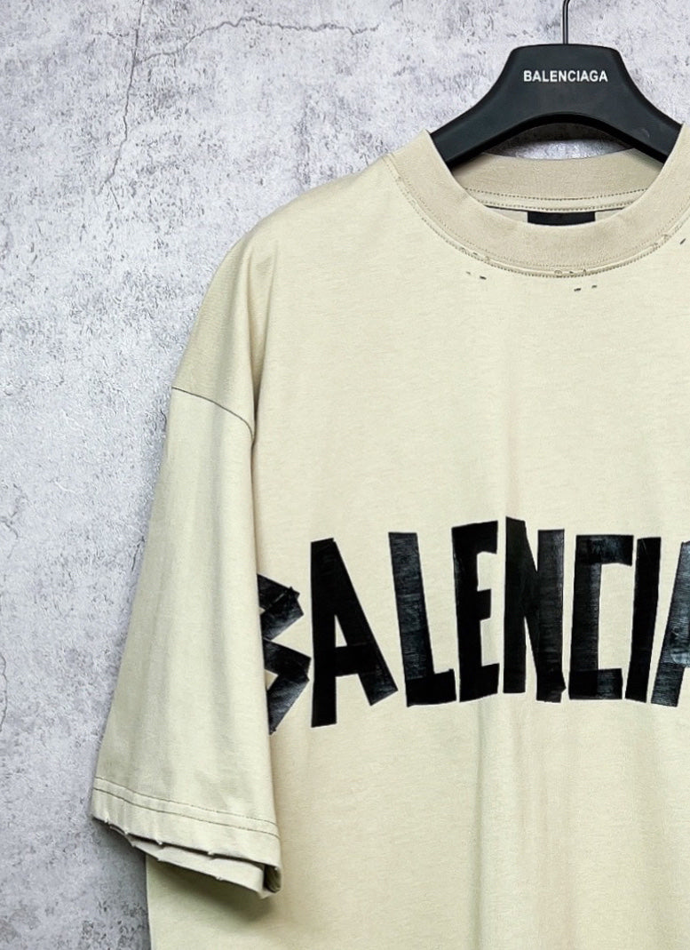 Balenciaga short-sleeve T-shirt shoulder view, pale yellow with partial black logo