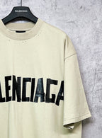 Balenciaga short-sleeve T-shirt sleeve detail, pale yellow with black logo text