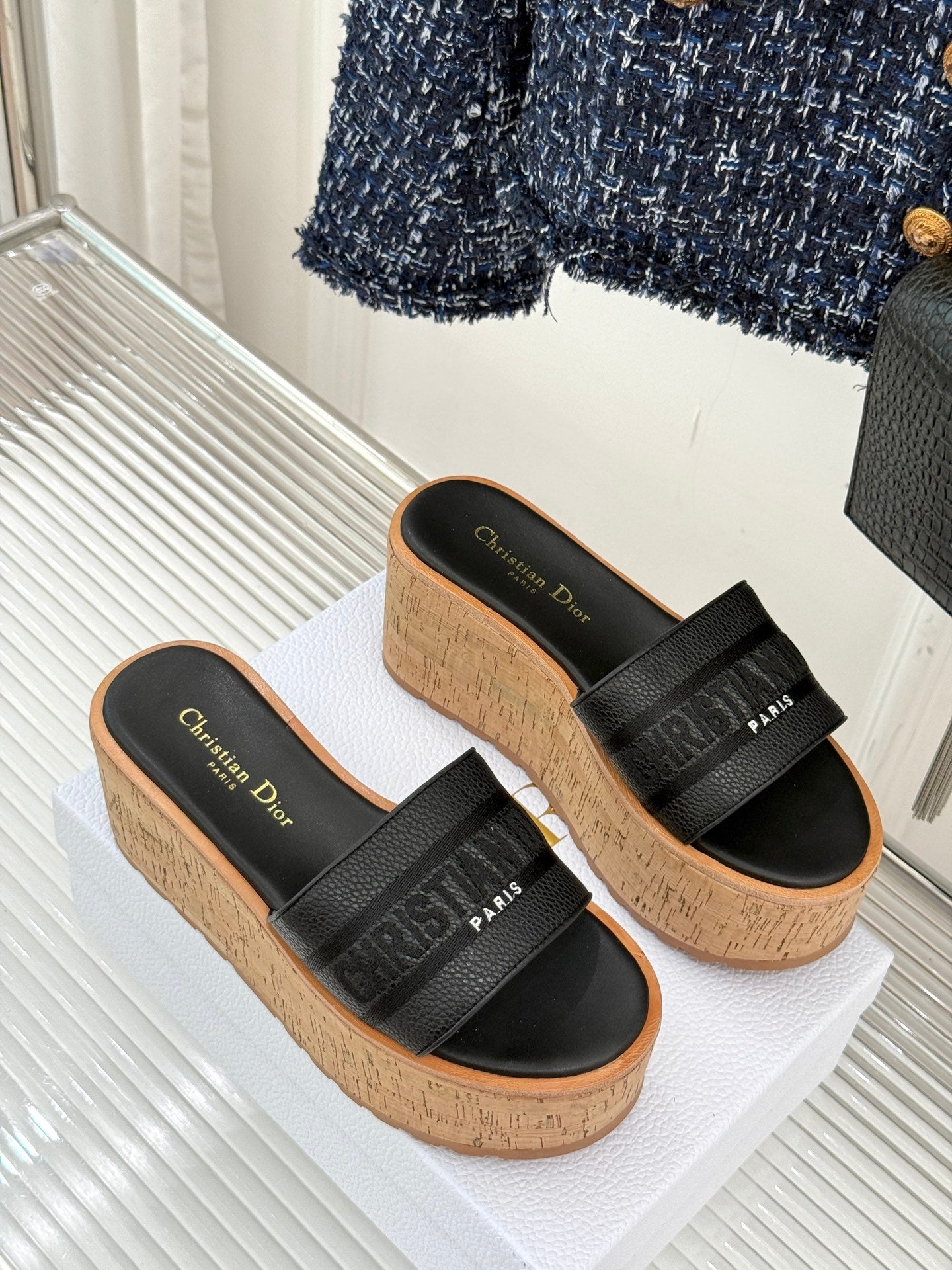 Black platform slide sandals with wide band straps and cork textured sole