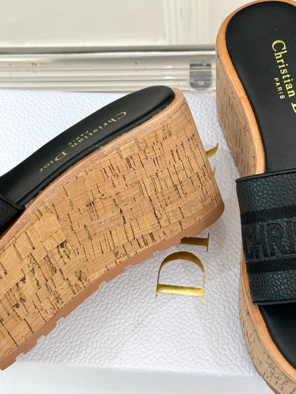Black slide sandal with cork platform and gold script logo on footbed