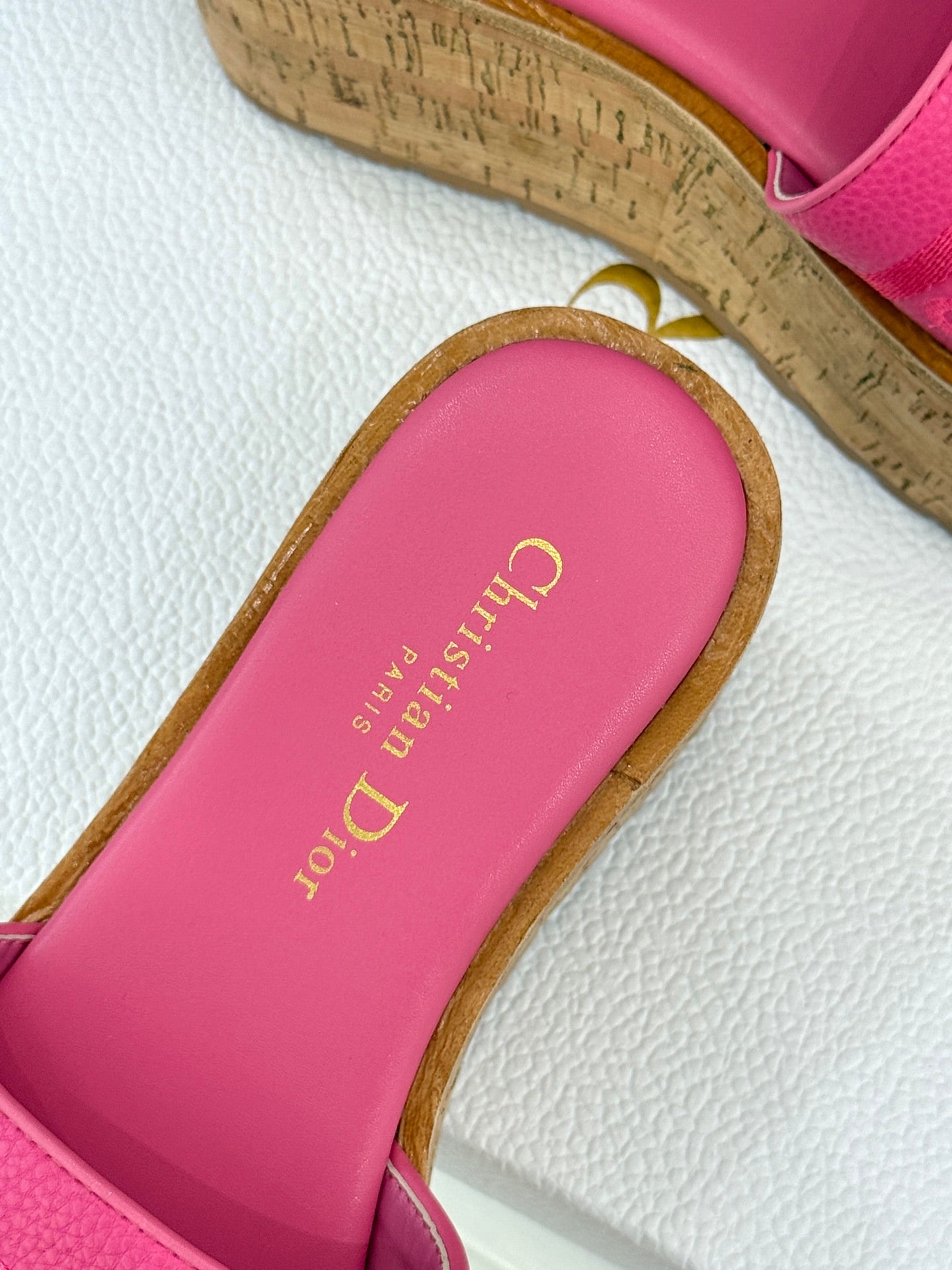 Close-up of pink Dior slide sandal footbed with gold “Dior” text