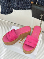 Pink Dior platform slide sandals on display, two shoes with cork-look wedges