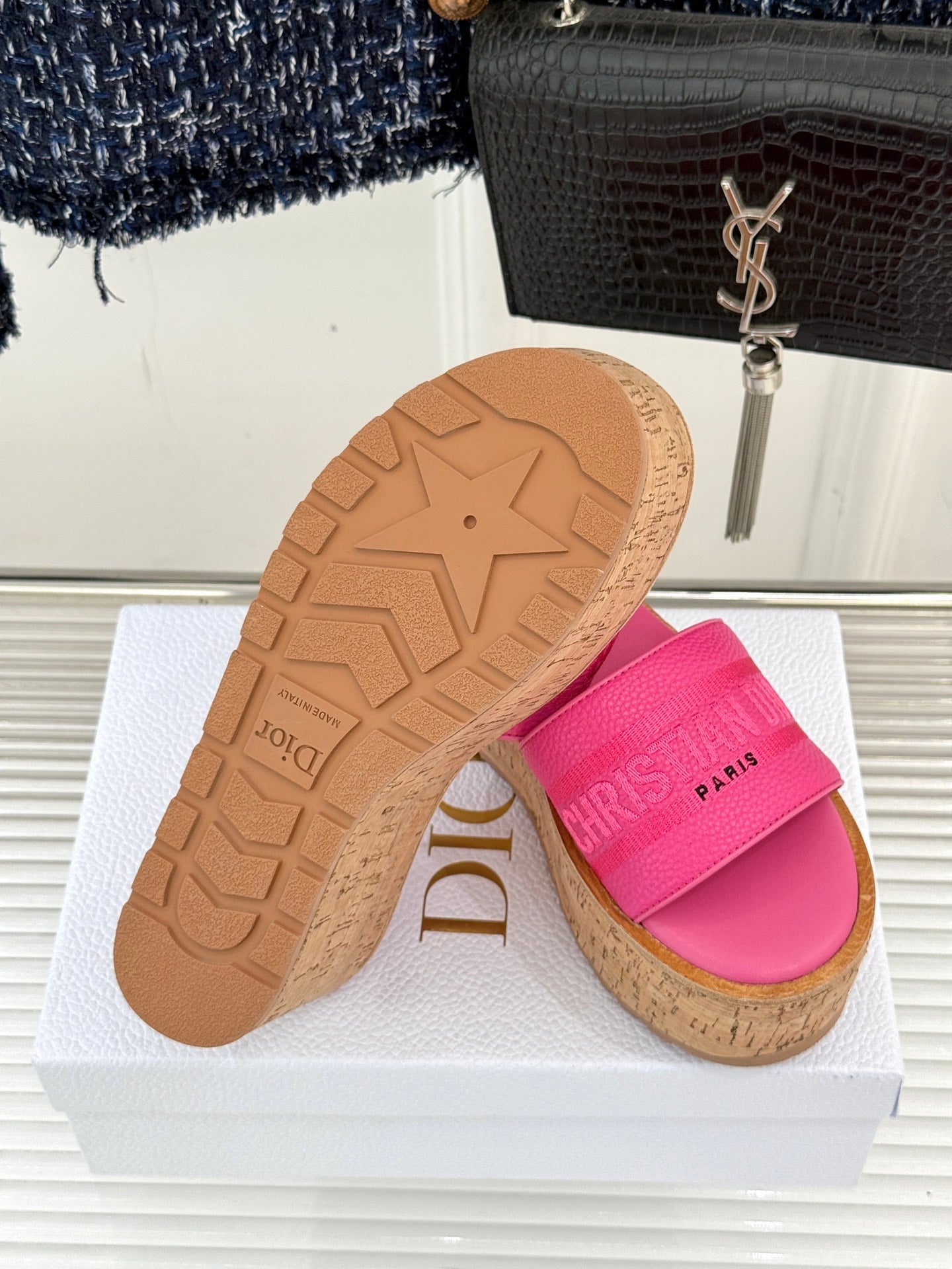 Outsole view of pink Dior platform slide sandals with tread pattern and cork edge