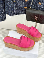 Pink Dior slide sandals with wide front strap and cork-look platform wedge