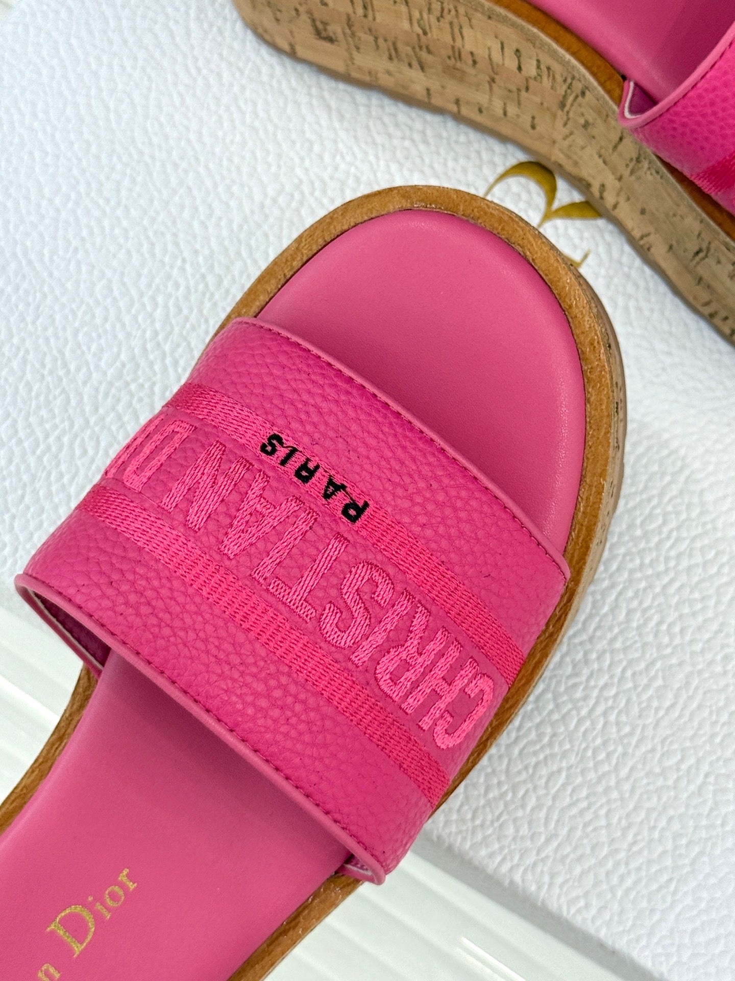 Close-up of pink Dior slide sandal strap with embossed logo lettering