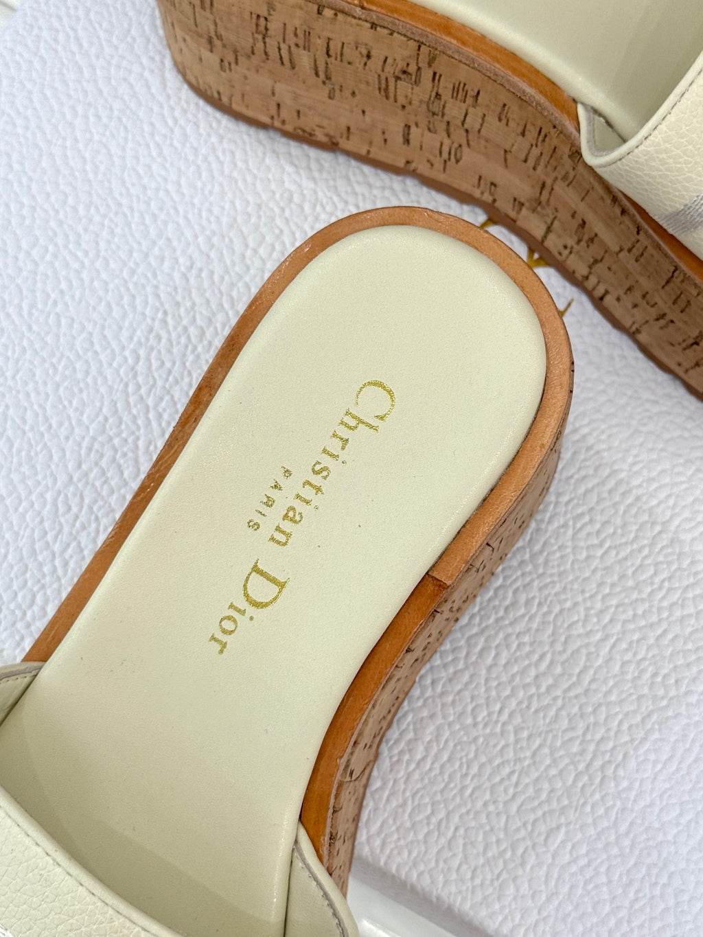 Dior slide sandal close-up of cream footbed with gold logo