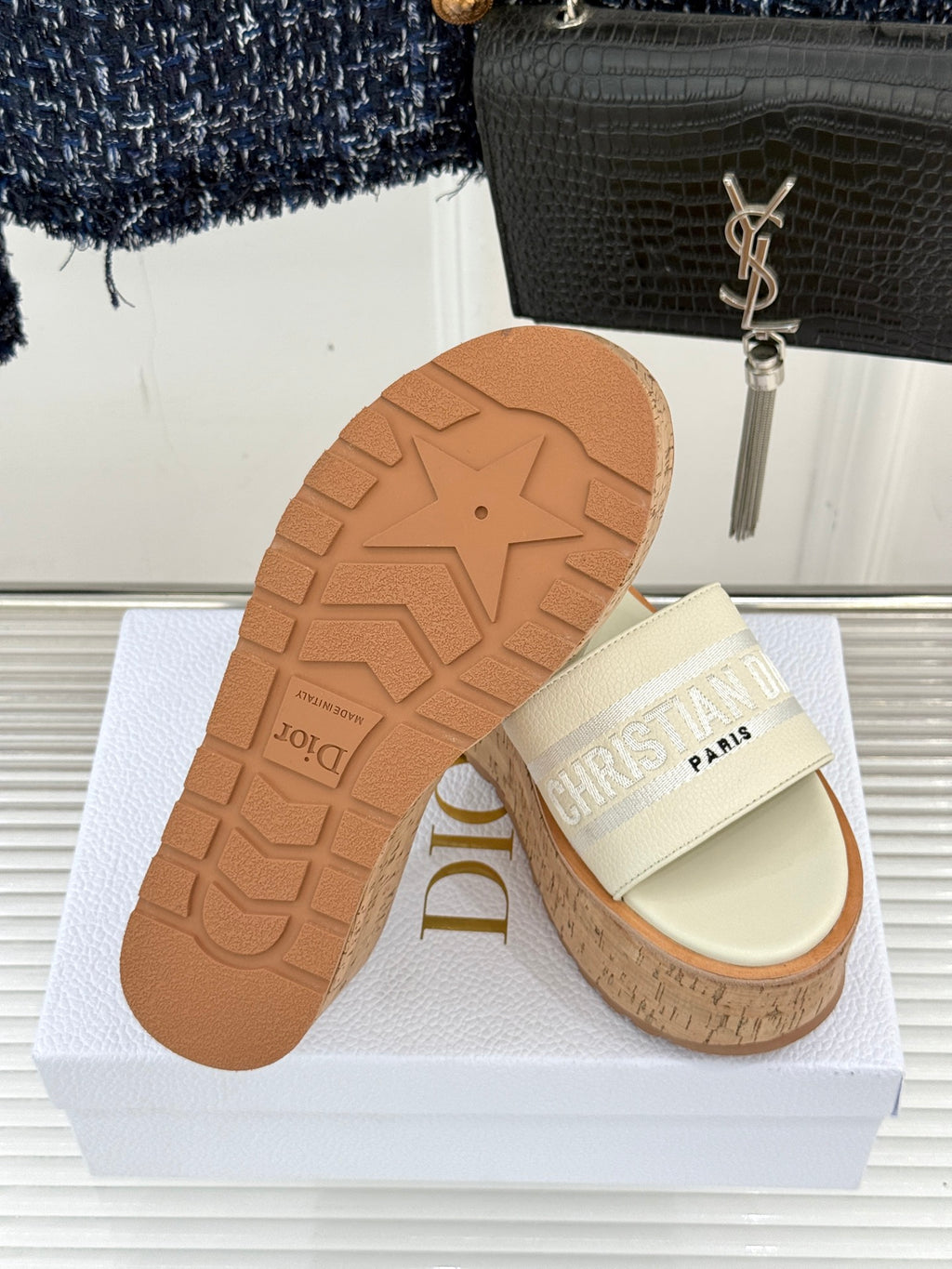 Dior platform slide sandals with cork sole and light cream straps, outsole visible