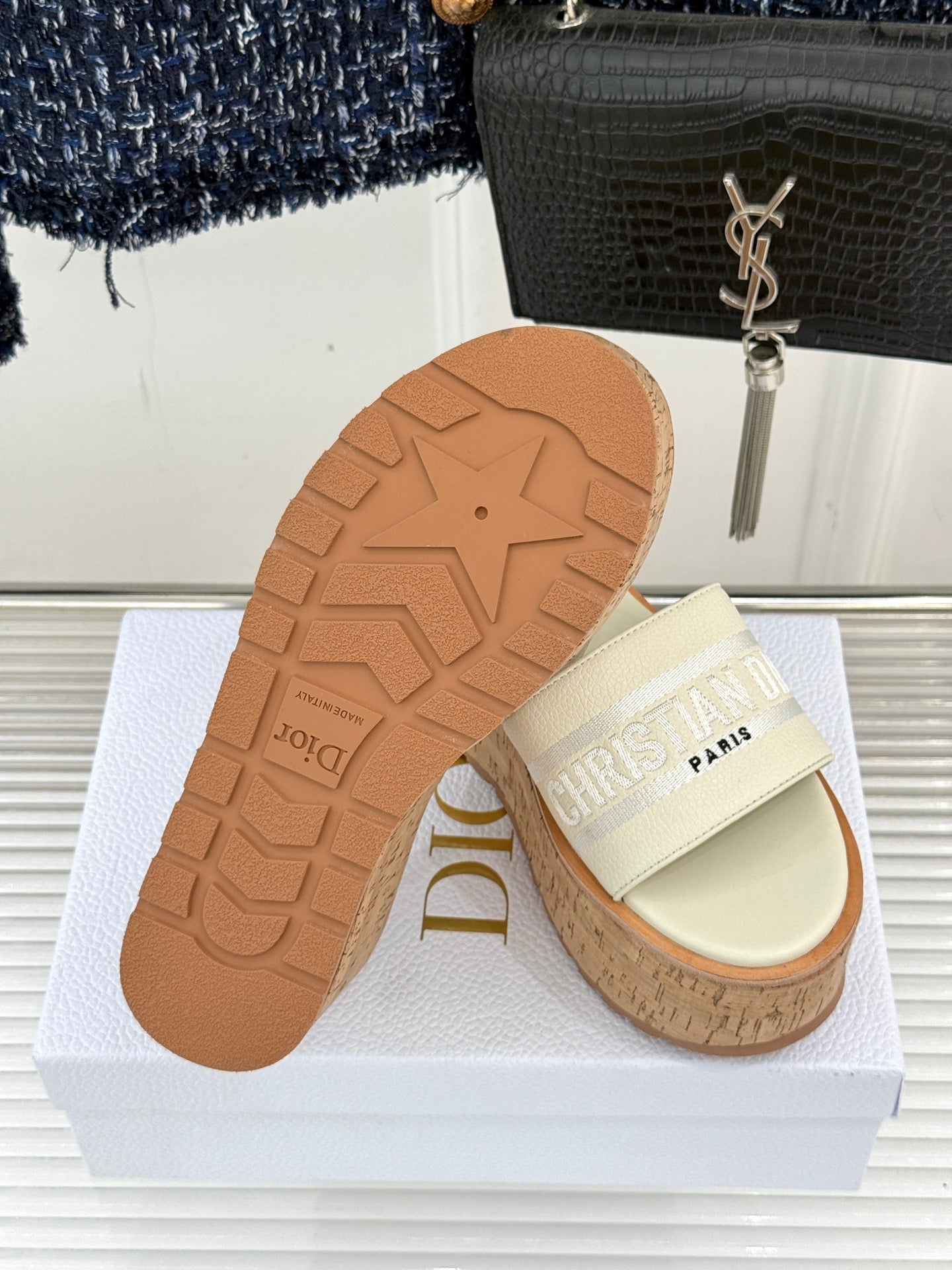 Dior platform slide sandals with cork sole and light cream straps, outsole visible
