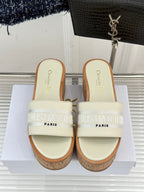 Dior platform slide sandals viewed from front with cream straps and cork soles