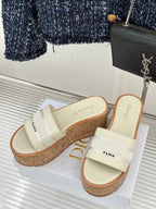 Dior platform slide sandals with cream straps, cork wedges, and side branding