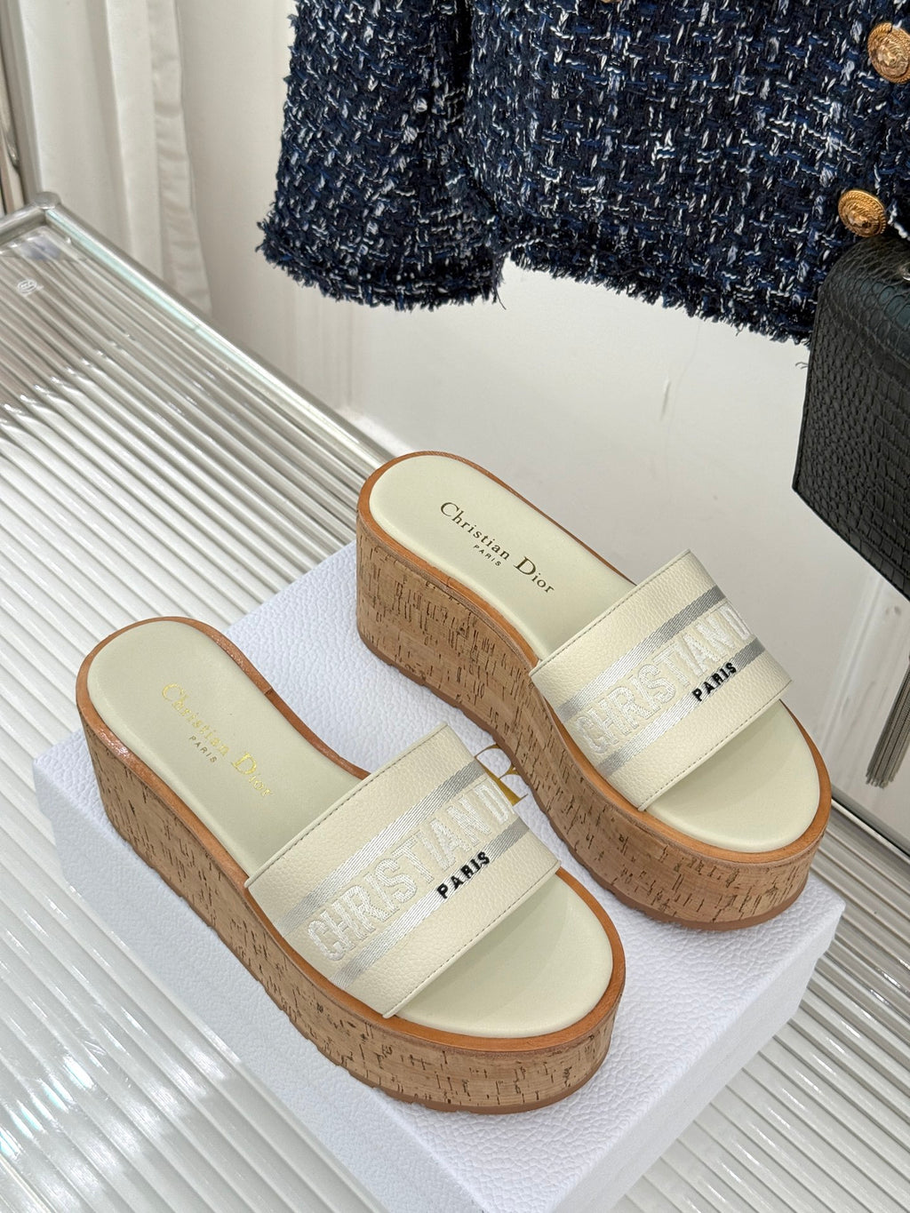 Pair of Dior platform slide sandals with cream straps and textured cork wedge soles