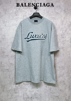 Balenciaga heather gray T-shirt with “Luxury” logo graphic on the chest
