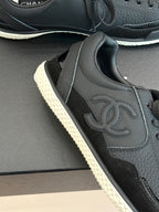 Dark leather sneaker upper with stitched Chanel CC logo and lace eyelets