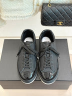 Dark leather lace-up sneakers with Chanel CC emblem and white interior lining