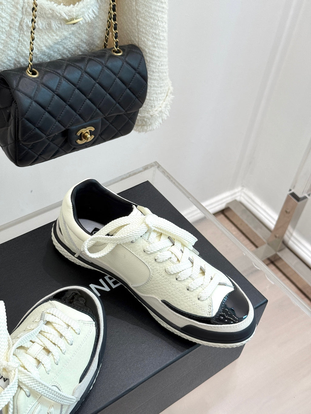 White low-top sneakers with black accents and chunky tread sole